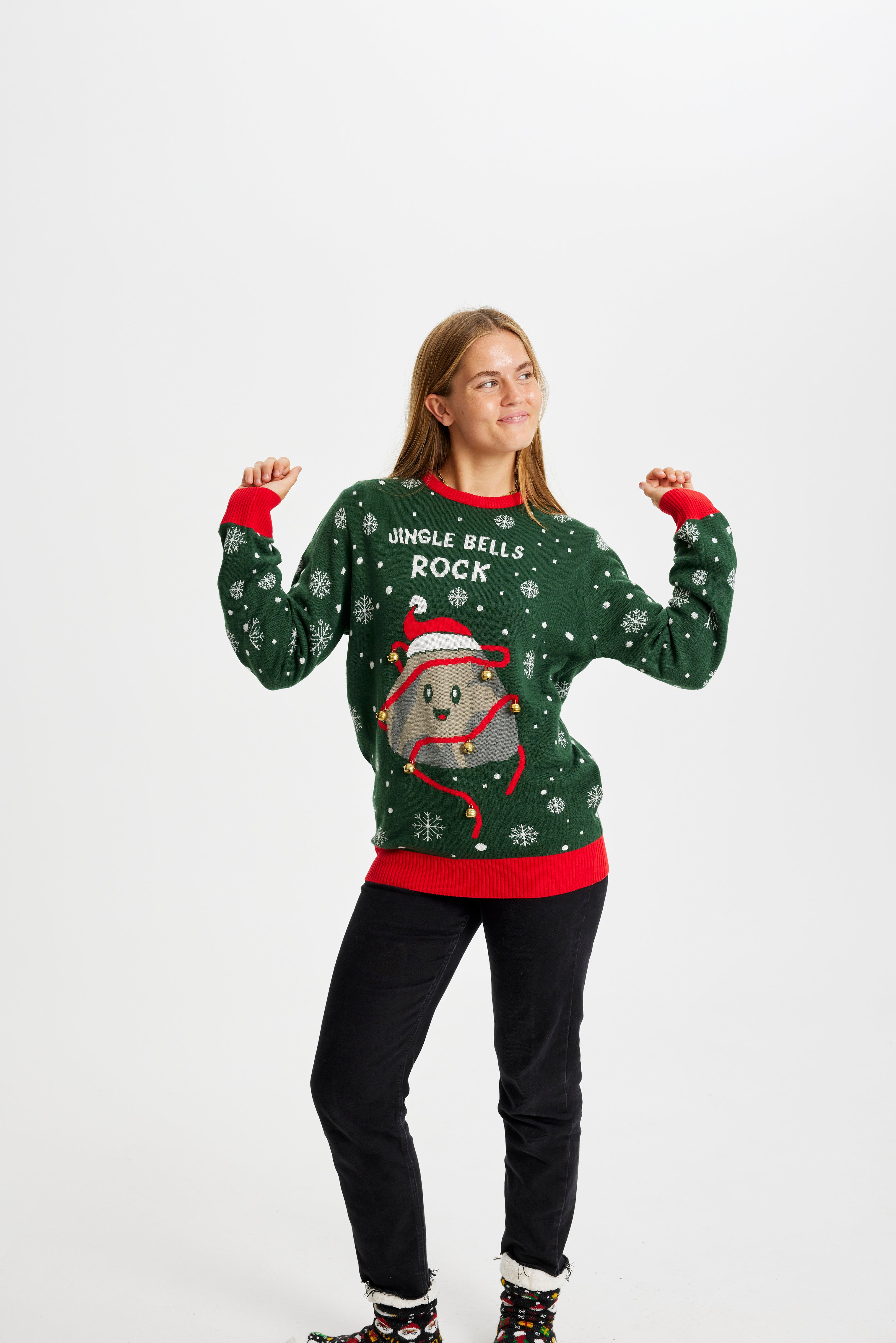 Una donna in posa che indossa un maglione natalizio verde con la scritta